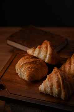 美味的黄油羊角面包木表格悬浮面包面包店产品咖啡馆概念