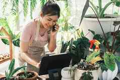 年轻的女人植物商店老板检查客户订单网站