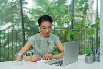 有吸引力的快乐的年轻的业务女人写<strong>笔记本</strong>电脑坐<strong>桌子上</strong>首席领袖在室内办公室