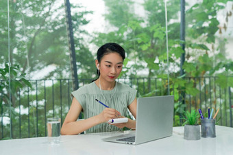 有吸引力的快乐的年轻的业务女人写笔记本电脑坐桌子上首席领袖在室内办公室