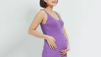 优雅的怀孕了女人触碰肚子白色背景