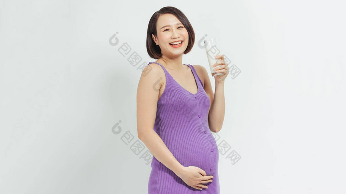 快乐怀孕了女人喝玻璃新鲜的牛奶触碰肚子护理