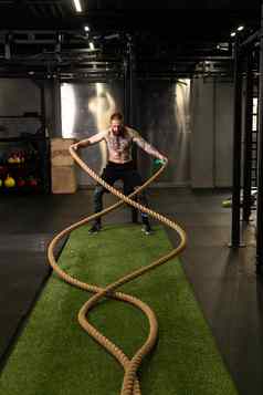 绳子培训男人。仓库健身健身房肌肉发达的锻炼锻炼锻炼概念强大的重身体运动员体育运动肌肉波站地面