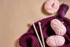 粉红色的针织纱球针织针紫色的针织格子前视图