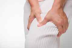 女人持有手膝盖痛苦膝盖疼痛联合疼痛关节炎肌腱问题白色背景关闭健康问题概念疾病肌肉骨骼系统