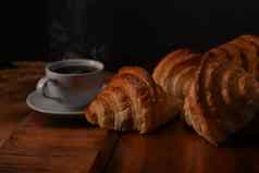 美味的羊角面包热咖啡木木董事会准备好了服务早餐早餐面包面包店产品咖啡馆概念