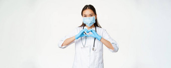 有爱心的亚洲医生女人医生医疗面具橡胶手套显示护理病人心标志白色背景