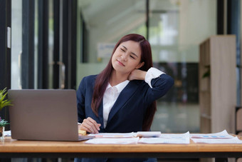 图像亚洲业务女人缓解疼痛脖子痛苦久坐不动的工作办公室并发症状概念
