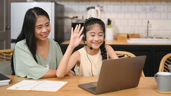快乐的亚洲女孩耳机会说话的老师研究在线移动PC首页快乐妈妈坐着附近的给支持