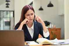 集中女经理坐着前面移动PC会说话的移动电话咨询客户端使业务调用工作