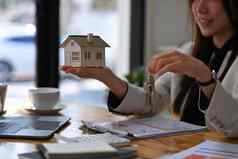 微笑女人持有房子模型房子关键手真正的房地产投资保险概念