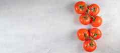 横幅红色的新鲜的美味的西红柿绿色嫩枝白色石头背景前视图