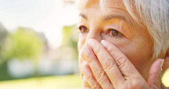 悲伤的错过爱特写镜头拍摄伤心高级女人擦拭眼泪脸在户外