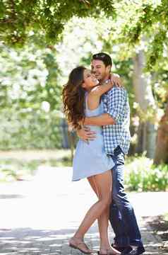 好玩的浪漫主义者完整的长度拍摄年轻的夫妇拥抱公园