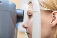 年轻的女孩接待眼科医生检查视力特殊的装置特写镜头