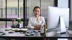 自信年轻的女业务企业家坐着个人办公室微笑相机