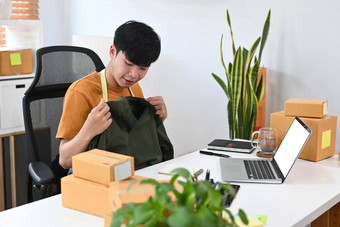 年轻的亚洲男人。显示衣服生活流媒体在线移动PC电脑