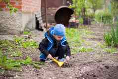 孩子种植花园孩子的耙手园丁男孩种植植物花床上园艺工具手孩子
