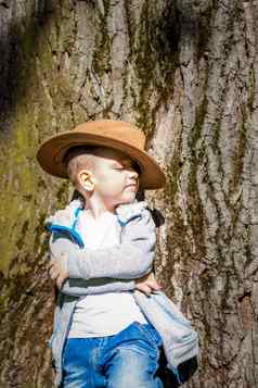 可爱的男孩摆姿势牛仔他森林树太阳的射线信封空间交互历史书空间复制