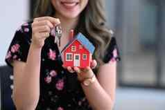 微笑亚洲女人持有房子模型房子关键手真正的房地产投资保险概念