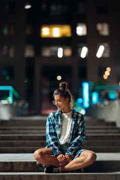 女人坐在长石头步骤晚上城市
