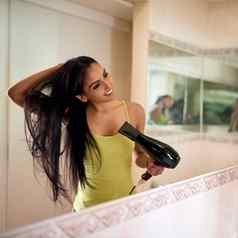 早....例程裁剪拍摄年轻的女人blowdrying头发浴室