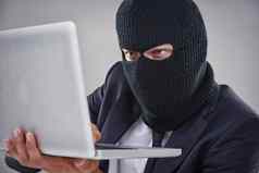 黑客秘密文件概念上的拍摄男人。面具头黑客电脑