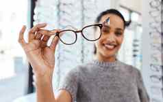 提高眼镜好眼睛健康拍摄年轻的女人购买一对眼镜验光师商店