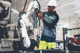 非洲美国工厂工人工作熟练的机器人手臂