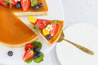 一块切片芒果芝士蛋糕站<strong>新装</strong>的浆果花健康的甜点素食者食物复制空间