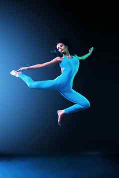 美丽的年轻的适合芭蕾舞舞者跳黑色的背景跳舞体育运动概念