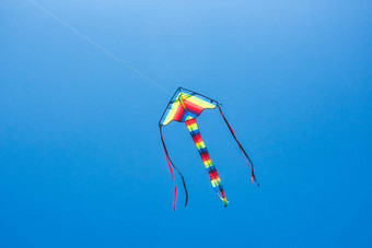 色彩鲜艳的风筝飞行清晰的蓝色的天空长尾巴飘带