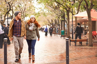 采取走冬天一边拍摄快乐年轻的夫妇走城市区域