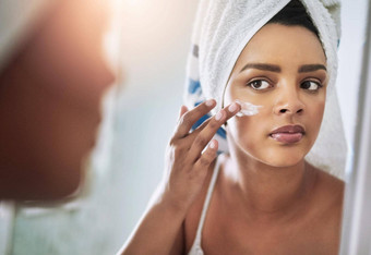 水合物皮肤好质量产品拍摄有吸引力的年轻的女人应用保湿霜脸浴室