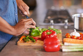 气质健康的餐裁剪视图男人。切蔬菜厨房计数器