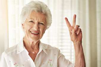 活力肖像快乐上了年纪的女人显示和平手势首页