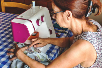 中年女人缝纫机使衣服