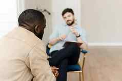 不开心年轻的黑色的男人。会话专业心理学家精神健康诊所专业心理概念