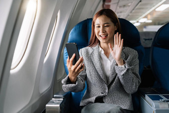 微笑年轻的亚洲女商人挥舞着手<strong>视频</strong>调用智能手机<strong>飞机</strong>