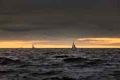 帆船海狂风暴雨的天气狂风暴雨的云天空橙色天空帆赛船会反射帆水比格尔波水