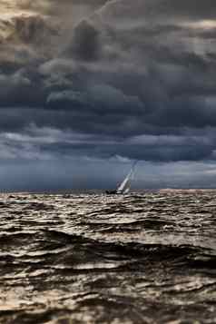 帆船海狂风暴雨的天气模糊背景狂风暴雨的云天空帆赛船会反射帆水大波水