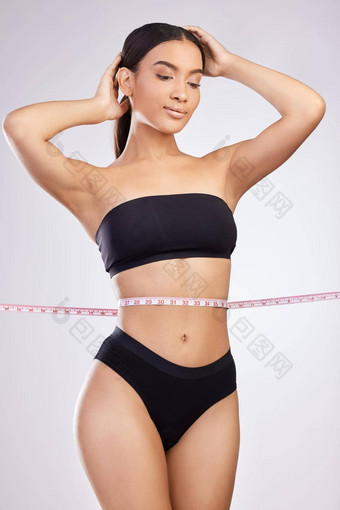 我最后失去了顽固的肚子脂肪工作室拍摄美丽的年轻的女人摆姿势磁带测量腰白色背景