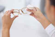 愿景更清晰的拍摄女人清洁一对眼镜