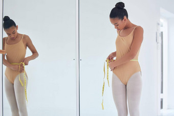 限制行业拍摄美丽的年轻的芭蕾舞舞者测量腰彩排