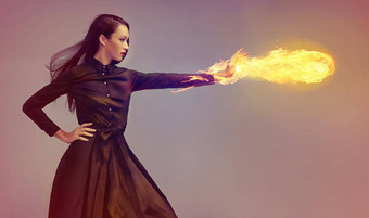 照明概念上的拍摄年轻的女武术艺术家释放火球