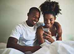 爱联合社会媒体账户拍摄快乐年轻的夫妇移动电话床上首页