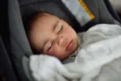 车旅行梦想拍摄可爱的婴儿男孩睡觉车座位