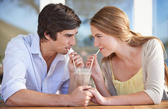 分享奶昔年轻的夫妇分享巧克力奶昔日期