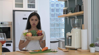 快乐的亚洲女人持有柳条篮子新鲜的有机蔬菜<strong>水果</strong>站现代<strong>首页</strong>厨房
