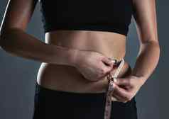 身体想要裁剪拍摄运动年轻的女人测量腰